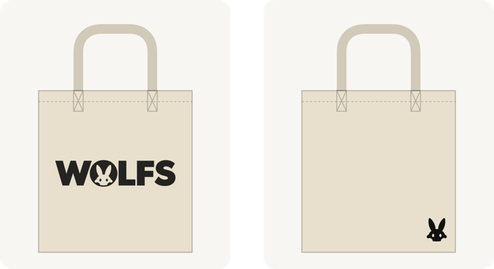 生成りのトートバッグの絵。左は表で、中央に黒い「WOLFS」の文字ロゴ（O の中にうさぎの顔）。右は裏で、右下に小さな黒いうさぎの顔。